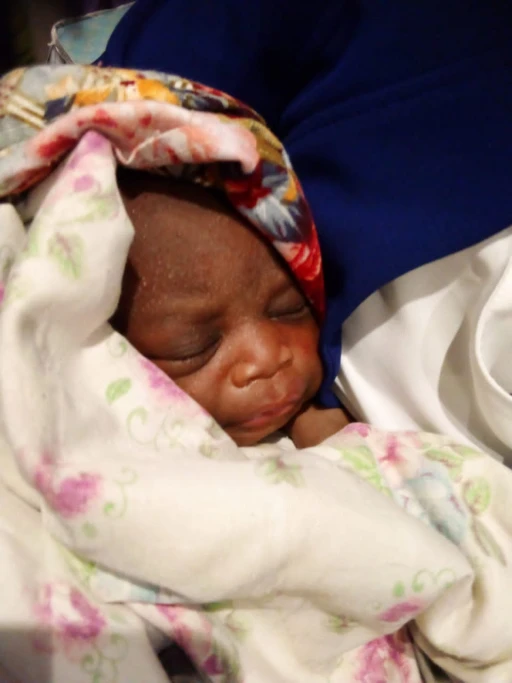 6-day-old baby recovered from a latrine, mother held